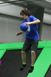 Boy Jumping to Avoid a Ball in Trampoline Dodgeball Game